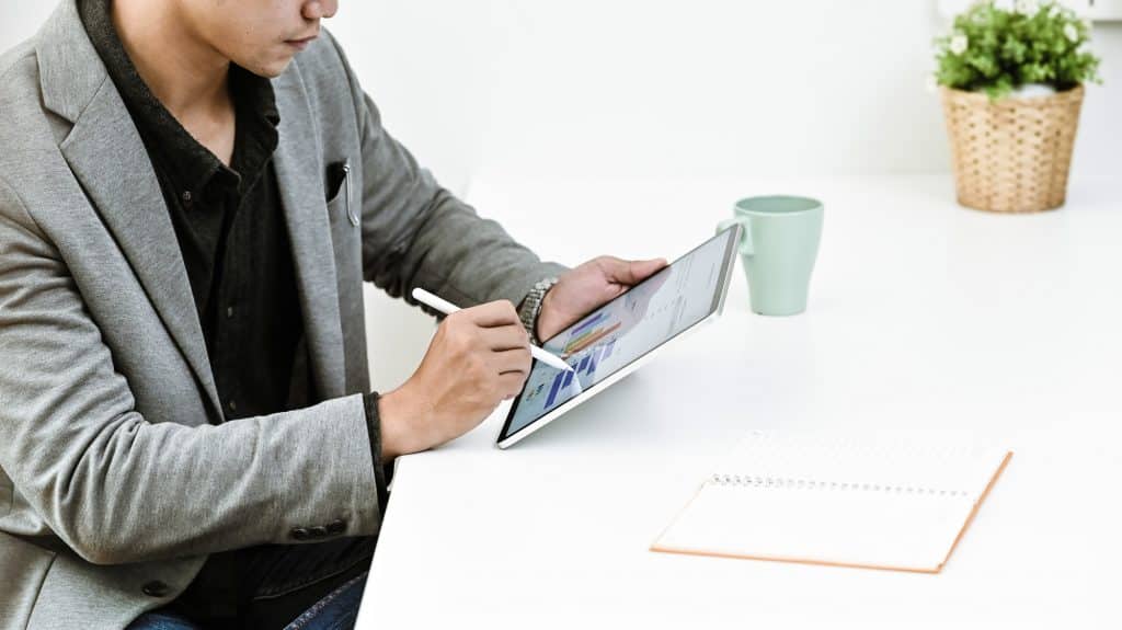 Cropped shot businessman analysis financial data in tablet.