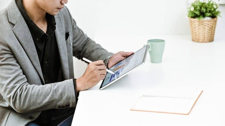 Cropped shot businessman analysis financial data in tablet.